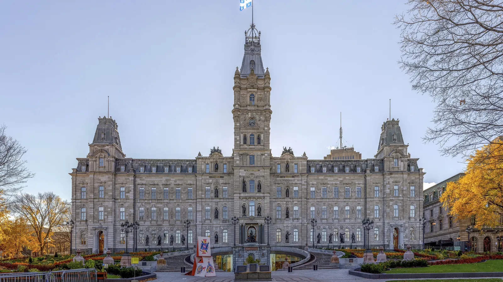 Façade de l'hôtel du Parlement du Québec, drapeau fleurdelisé au sommet de la tour, feuillage d'automne